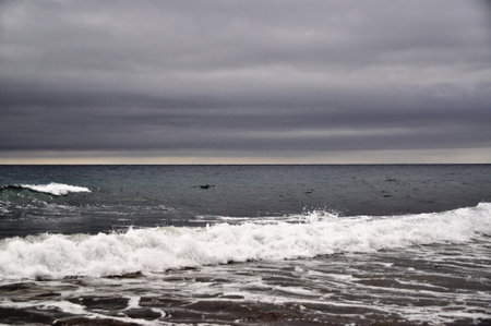 Evening ocean waves under cloudy sky horizon;の写真素材
