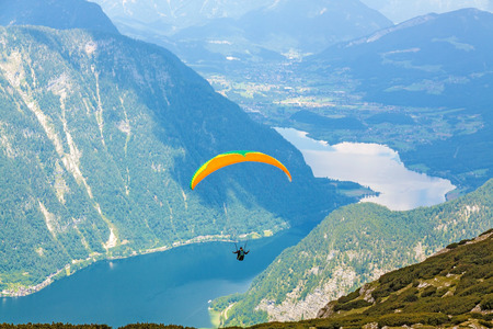 Paraglider over Lake Hallstatt at Dachstein mountainsの写真素材