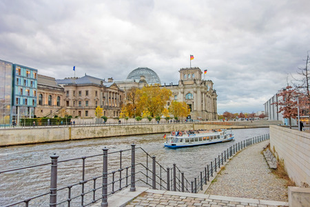 Berlin, Germany - October 28, 2013: Spree river with sightseeing passenger boat and Reichstag building in the background. Government district in Berlin-Mitte, where politic is made in Germany.のeditorial素材