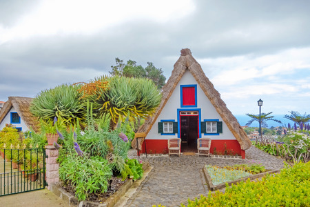 Santana, Portugal - June 7, 2013: Flower's related craft souvenir shop built like a typical triangular house, Island of Madeira.のeditorial素材
