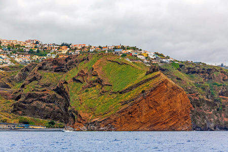 Cliff coast off town Canico, Madeira - offshore view, dramatic sky, sunsetの写真素材