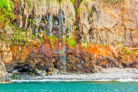 Colorful rocky cliff coast of Madeira between Jardim do Mar and Calhetaの写真素材