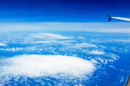 over the clouds, view during a flight over the blue oceanの写真素材