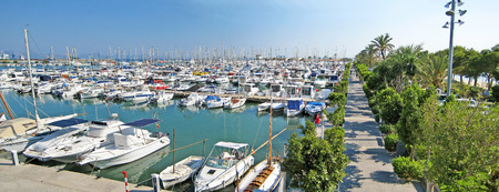 Alcudia, Majorca, Spain - June 26, 2008: Port panorama of Alcudia from bridge - boats and ships laying in harbor, promenade aside.の写真素材