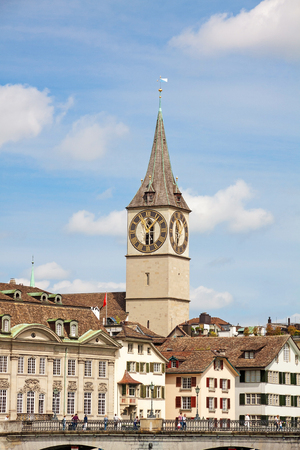 Zurich, Switzerland - June 10, 2017: Church Saint Peter in downtown Zurich, bridge over river Limmat in front.のeditorial素材