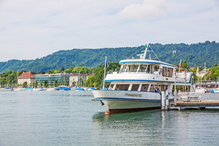 Zurich, Switzerland - June 10, 2017: Excursion boat "Pfannenstiel" arriving at shipping pier Burkliplatz. Western bank of Lake Zurich, Mythenquai / Enge in background.のeditorial素材