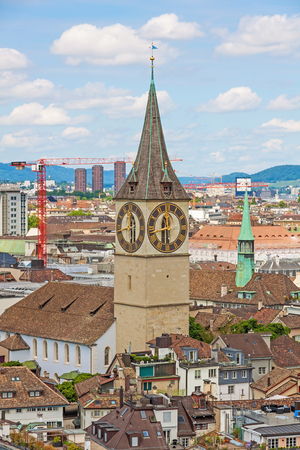 Zurich, Switzerland - June 10, 2017: Church Saint Peter in downtown Zurich, Switzerland, bridge over river Limmat in front. View through trees.のeditorial素材