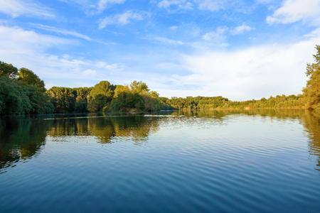 idyllic water landscape, lake with trees aroundの写真素材