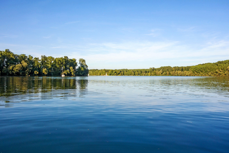 idyllic water landscape, lake with trees aroundの写真素材