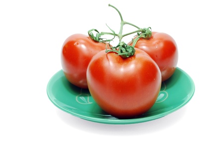 Isolated Three Red Tomatoes on Plate on Whiteの写真素材