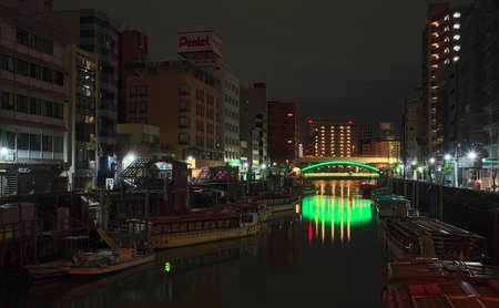Tokyo, Japan - October 16 2020: Late night view of a number of boats moored along the Kanda River in central Tokyo, with an illuminated bridge visible in the distance and high-rises all aroundのeditorial素材