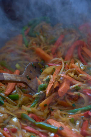 Vegetables with beer chicken mixing with wooden spoonの写真素材