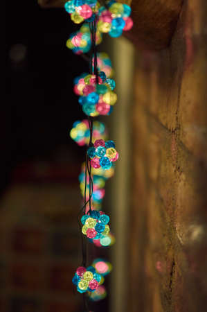Colorful Christmas lights on a pebble wallの写真素材