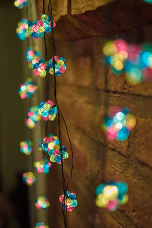 Colorful Christmas lights on a pebble wallの写真素材