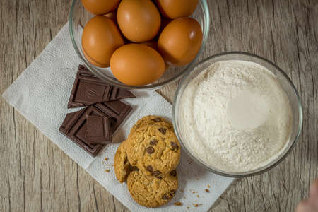Homemade oatmeal cookies on wooden board on old table with eggs background. Healthy Food Concept.の写真素材