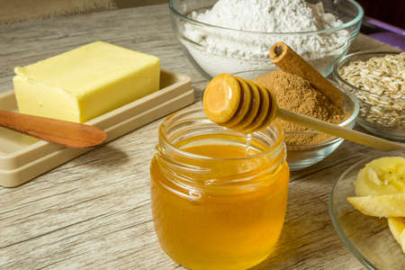 Ingredients for making healthy biscuit. Banana, Oats's Flour, Honey, Cinnamon and Butter on wooden table.の写真素材