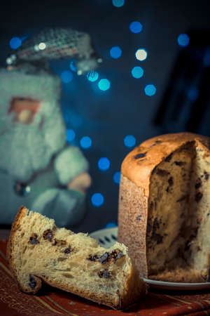 Panettone. Traditional italian dessert for christmas with chistimas light on backgroundの写真素材