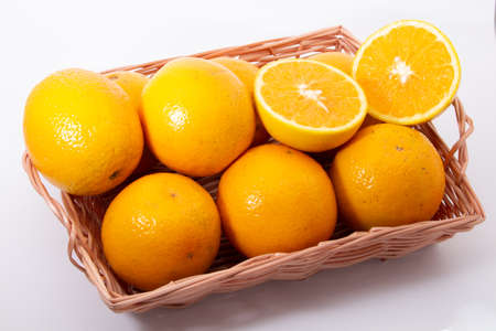 Some oranges in a basket on wooden backgroundの写真素材