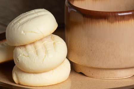 Small round cookies and Cup of coffee in brown dish on wooden table
