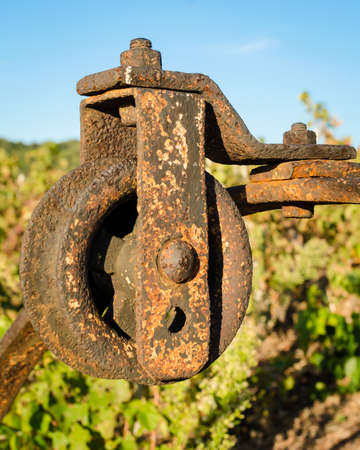 Old rusted pulley of an old well in a vineyardの写真素材