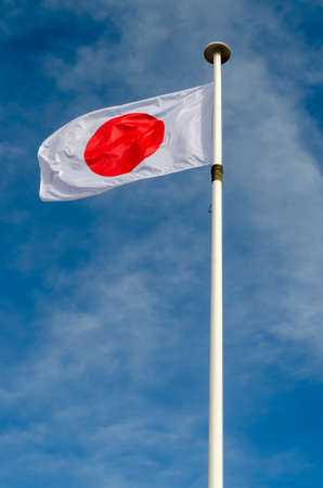 A Japan flag is floating in a blue sky