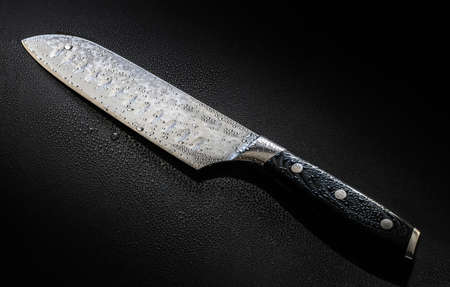 Knife with water drops isolated on a black backgroundの写真素材