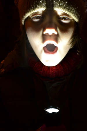 Child Playing With  A Flashlight In Darkness