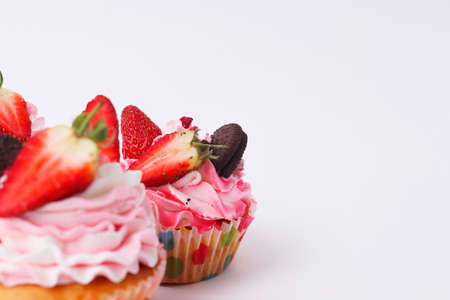 Three cupcakes on a white background. Srtawberry and blueberry cake. DIY cake. Cake for advertising a pasty shop. Cake on a white background with place for textの写真素材