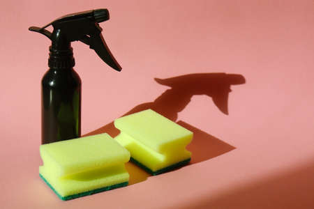 Household cleaning products. Dishwashing sponges. Maintaining cleanliness in the house. Zero waste lifestyle. Cleaning spray and sponges on pink backgroundの写真素材