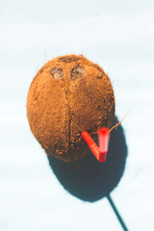 fresh coconut with straw on colored background,summer and healthy concept, minimal styleの写真素材