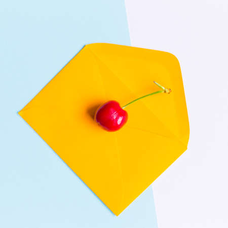 isolated cherry on an envelope, in a contemporarypastel colored background, minimal themeの写真素材