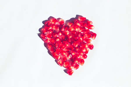 heart of vibrant pomegranate on white background, minimal pop conceptの写真素材