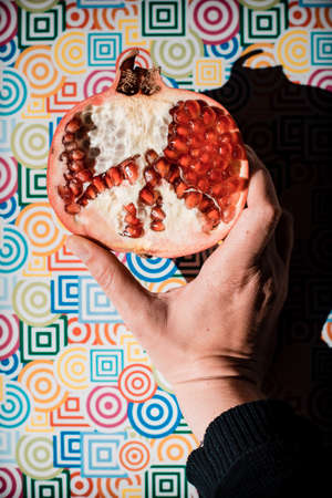 ripe red pomegranate on colored trendy background, summer healthy conceptの写真素材