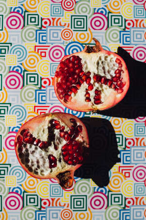 ripe red pomegranate on colored trendy background, summer healthy conceptの写真素材