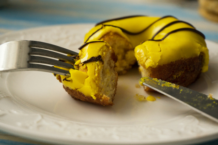 yellow donut on a plate with cutleryの写真素材