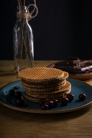 wafer in liquid chocolate with cherryの写真素材