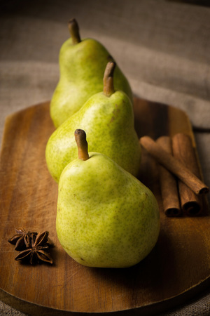 three rustic pears on a board with spicesの写真素材
