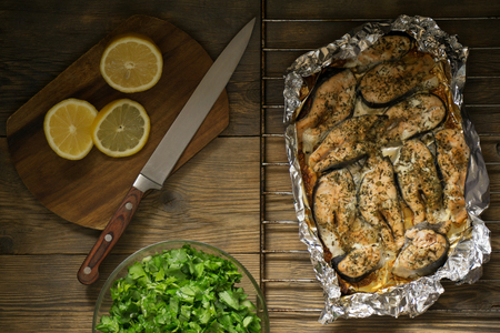 baked fish with lemon and greensの写真素材