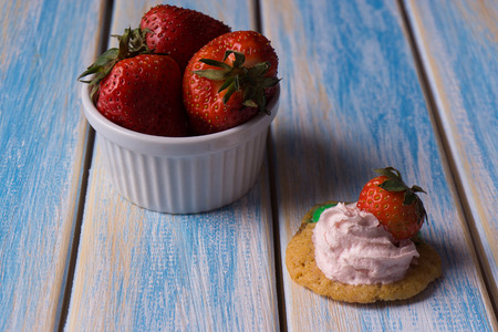 strawberry in a bowl on a wooden backgroundの写真素材