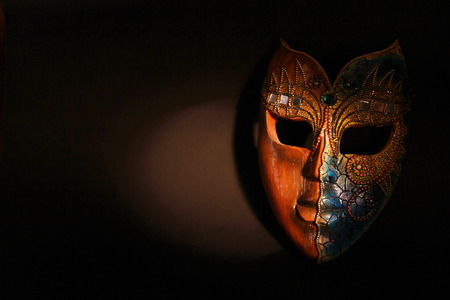 Beautiful Brown Wood Mask With Gems And Designing On It In Dramatic Spot Lightの写真素材