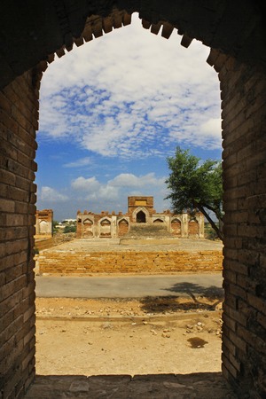 A beautiful view of tomb from a wall in a wall with some blue skys and clouds in makli grave yard, Sindh, Pakistanの写真素材