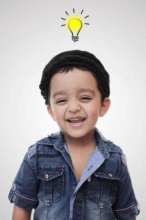 Portrait. happy little south asian boy wearing cultural hat. smiling and looking in the camera isolated on whiteの写真素材