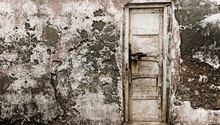 Old wooden door on a old cracked old wall full texturedの写真素材