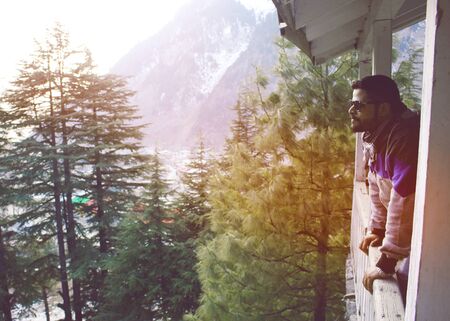 Guy standing on terrace of a cottage in mountain of Naran Valley, KPK, Pakistanの写真素材