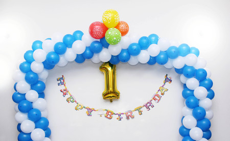 First birthday, anniversaey decoration on white wall - Number 1 in golden colorの写真素材