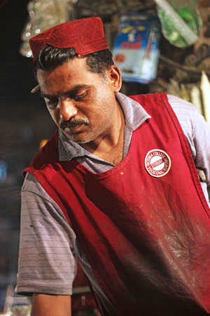 Sales man wearing sindhi hat selling achaar at saddar bazar karachi, Pakistan 15/03/2013のeditorial素材