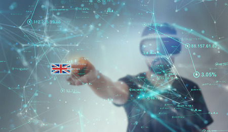 Young Guy in black t shirt looking through VR (Virtual Reality) glasses - Pointing Finger on screen England flagの写真素材