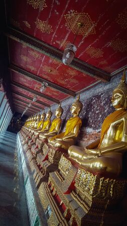 Golden Meditating Buddha Statues Sitting In A Row In A Corridor In Wat Suthat Thepwararam Temple Bankok, Thailand 25/11/2019のeditorial素材