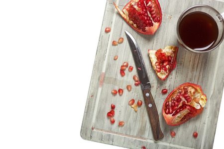 Fruits of pomegranate on a cutting board. A glass of juice from a pomegranate.の写真素材