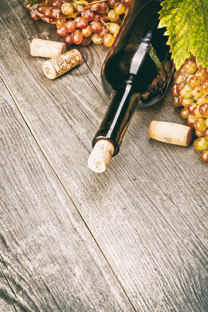 Bottle of wine with grape and corkscrew on a wooden backgroundの写真素材